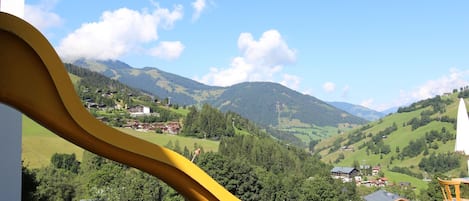 Vista de un paisaje montañoso con edificios y un tobogán amarillo en primer plano.