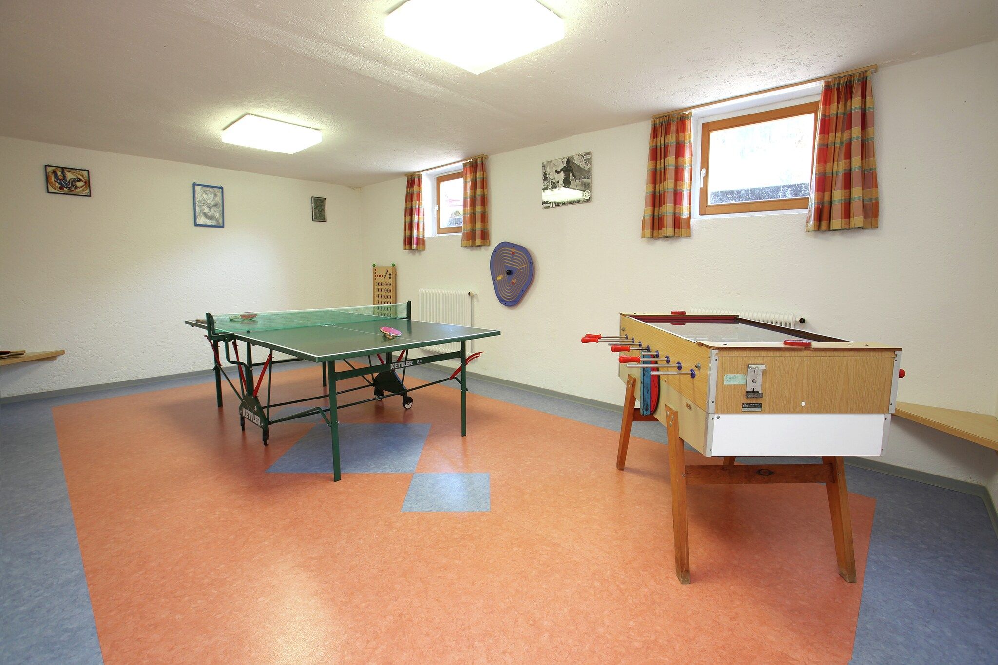 Ein Zimmer mit Kicker, Pong-Tisch und einem rollbaren Kicker.