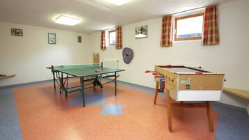 Ein Zimmer mit Kicker, Pong-Tisch und einem rollbaren Kicker.