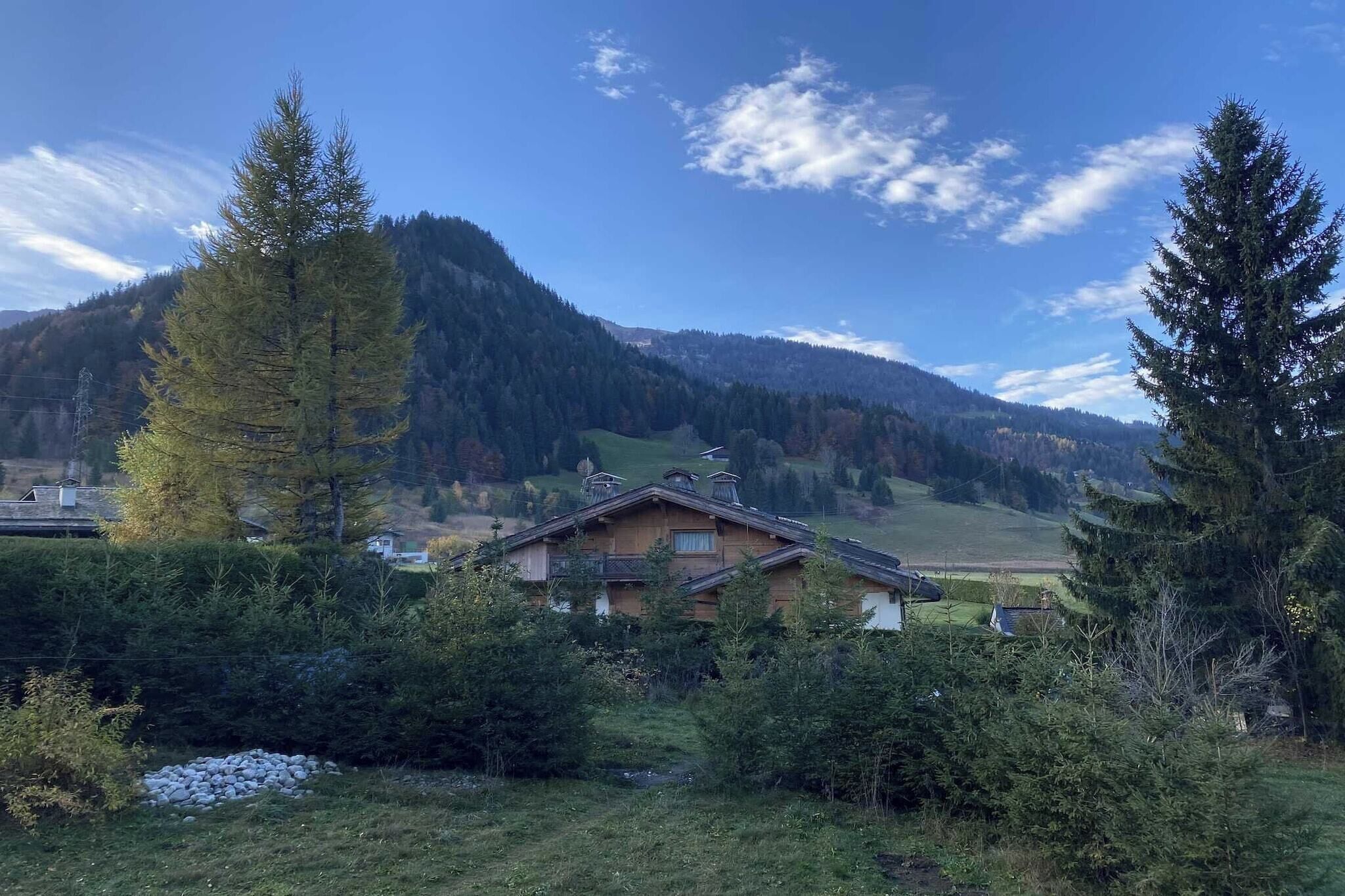 A house surrounded by trees and mountains.