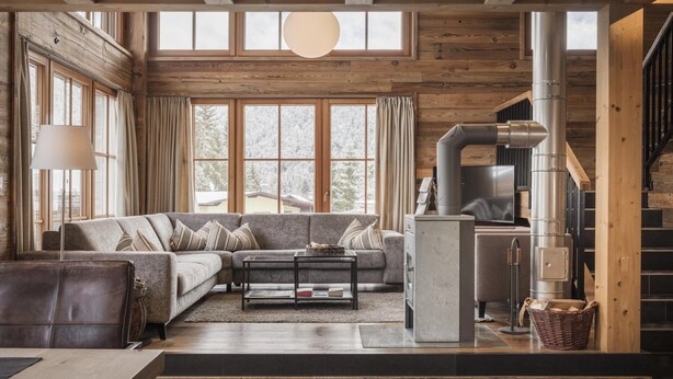 A cozy living room with a sofa, coffee table, and fireplace. - Charming Alpine chalet in Weidach (Leutasch)