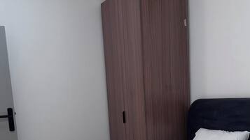 Ein Schlafzimmer mit zwei Betten, einem Kleiderschrank und einer Klimaanlage.