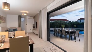 Un interno moderno con zona pranzo, TV e vista esterna.