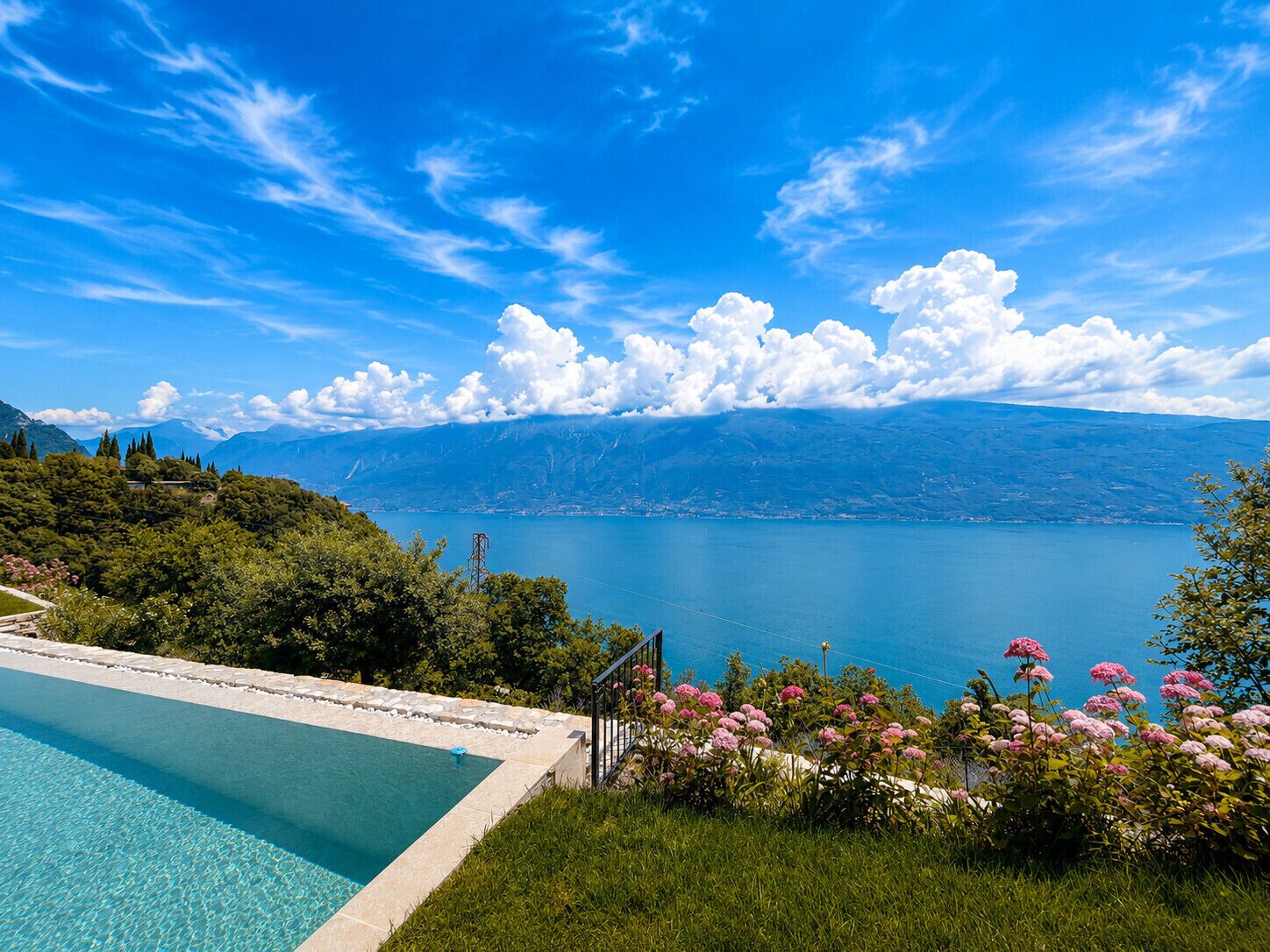 A swimming pool with a view of a lake and mountains.
