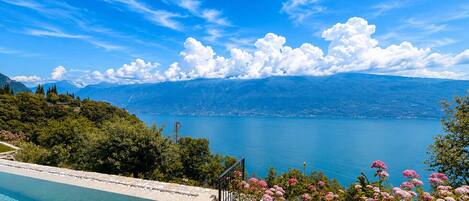 A swimming pool with a view of a lake and mountains.