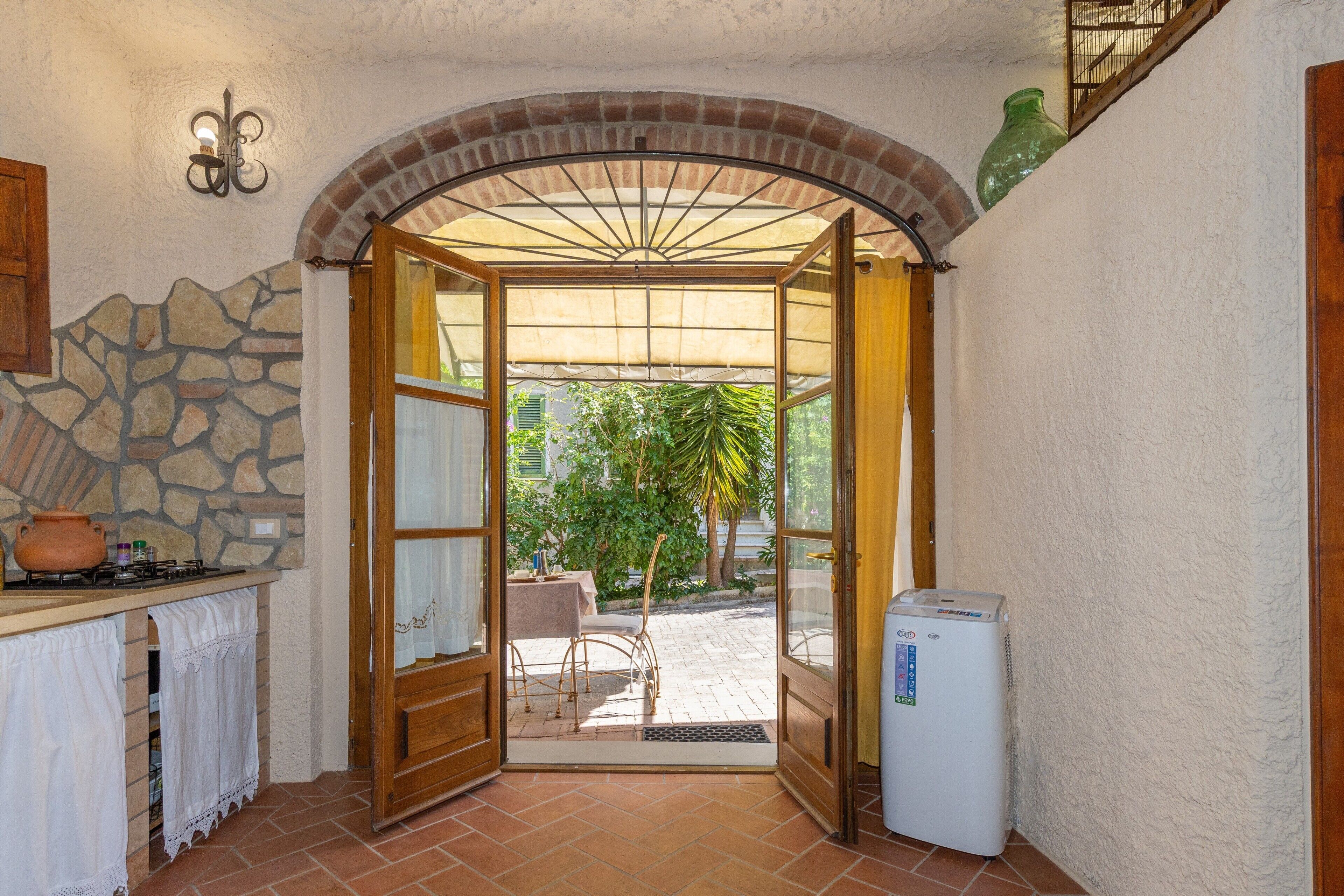 A kitchen with a stone wall, a wooden counter, a stove, and a refrigerator.
