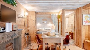 Un interno in legno con un tavolo da pranzo, sedie, una televisione e un caminetto.