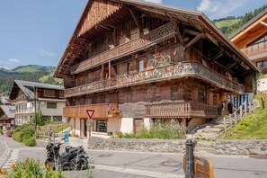 A traditional wooden chalet with balconies, a visible sign, and a mountain backdrop. - Les Évouettes - Châtel Village (Châtel)
