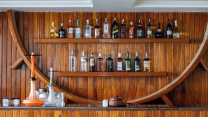 Un bar con estantes de madera que exhiben diversas botellas de licor.