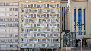 Un hotel de varios pisos con una fachada en zigzag llamativa, ventanas grandes y un letrero de casino.