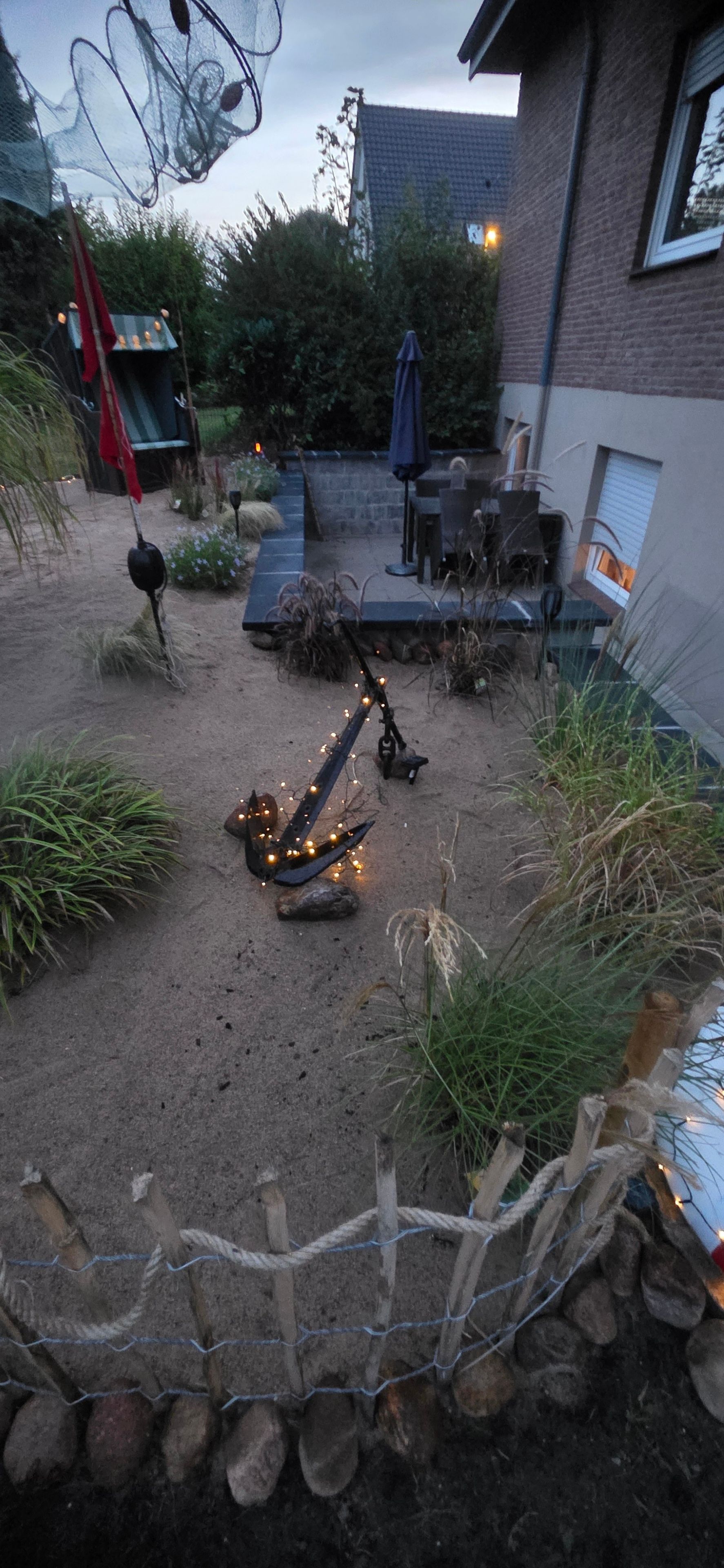 A backyard with a fire pit, outdoor furniture, and a wooden fence.