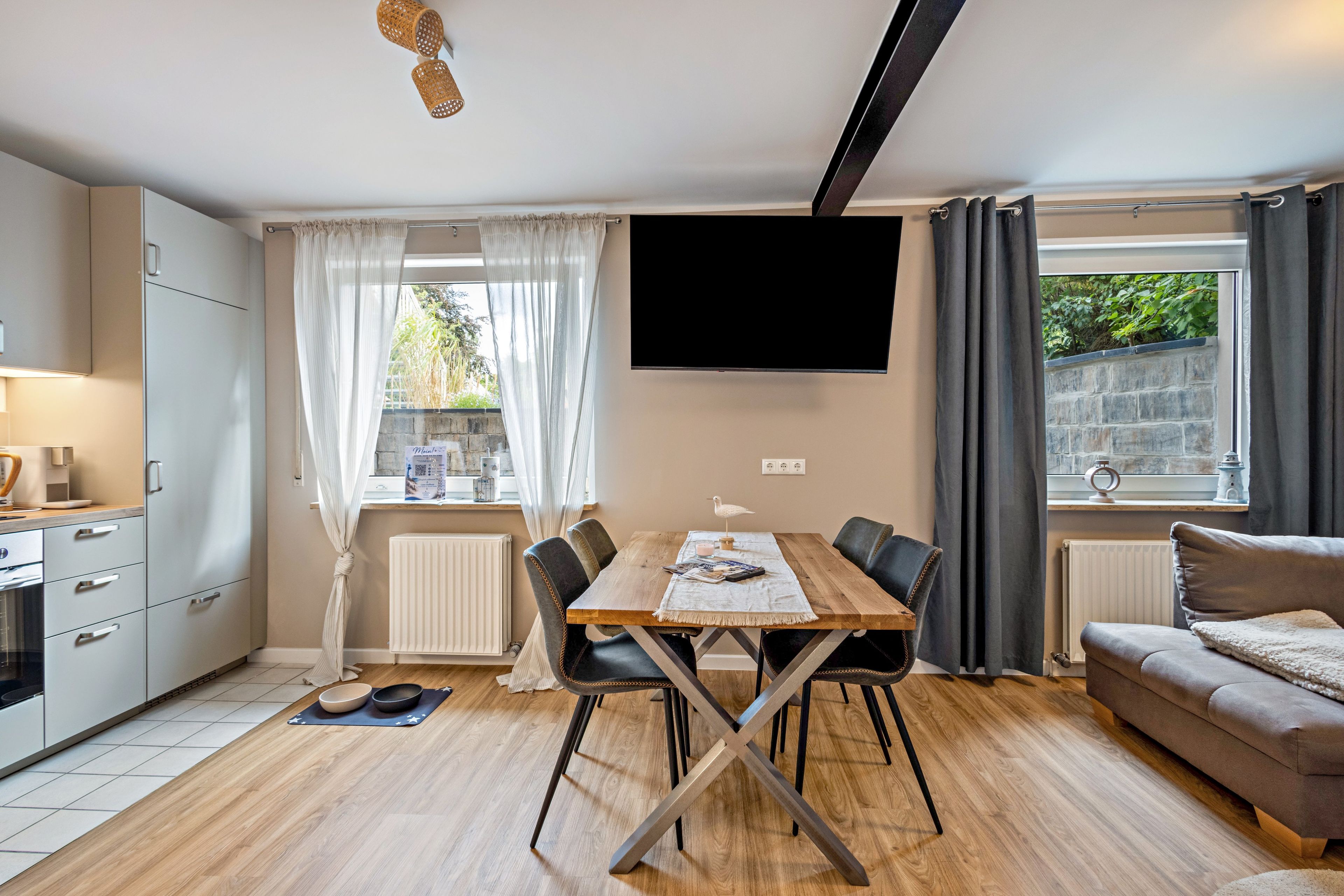 A modern living space with a dining area, kitchen, and seating area.