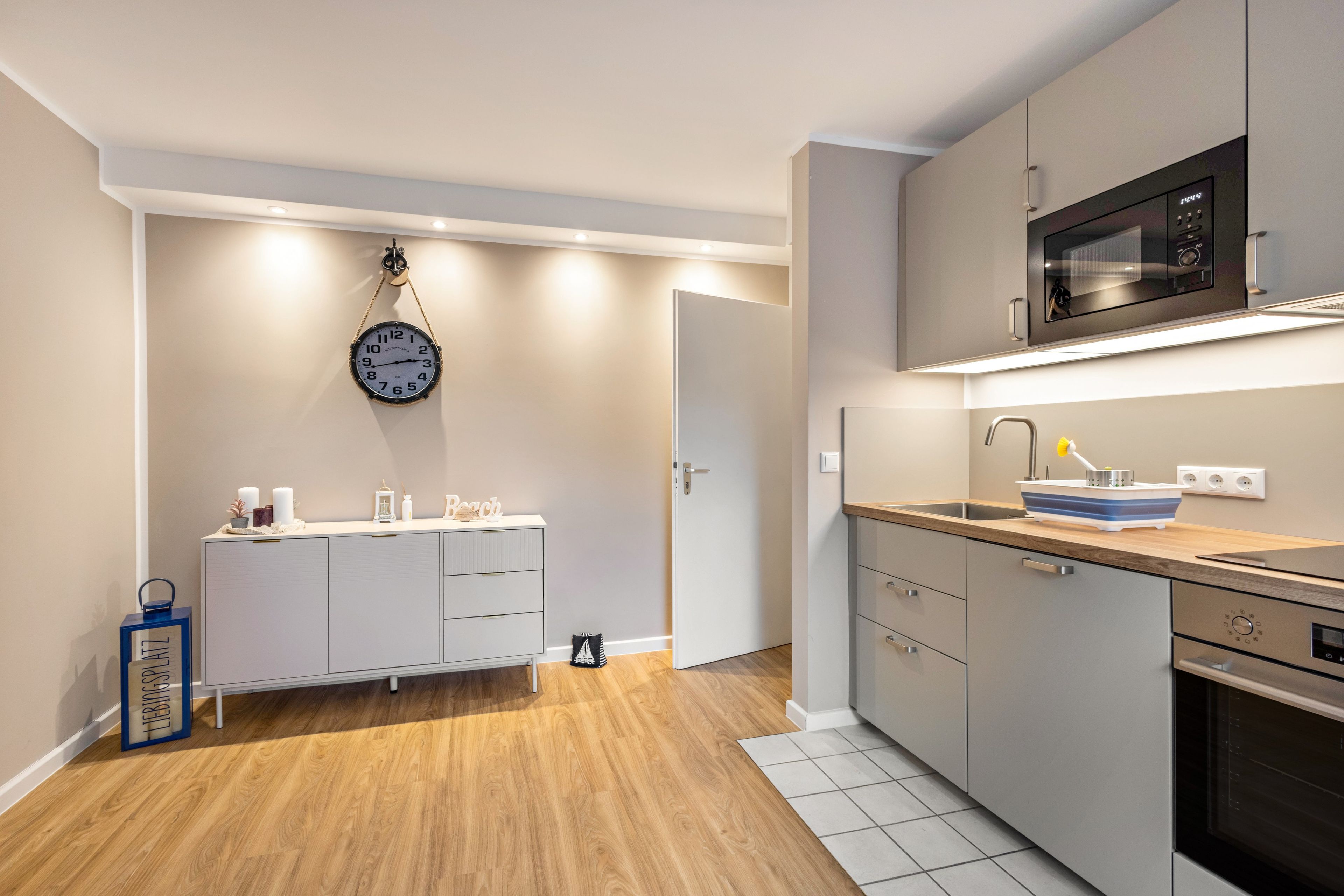 A modern kitchen with a microwave, sink, and cabinets.