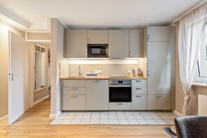 Eine moderne Küche mit integriertem Mikrowellenherd, Backofen und Spüle.