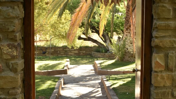 A stone pathway leading to a stone building entrance. - Konka Guest Farm (Carnarvon town)