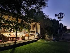 A patio area with outdoor furniture, a windmill, and a building with a fireplace. - Konka Guest Farm (Carnarvon town)