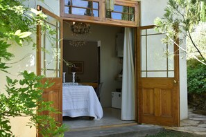 A wooden door leading to a room with a bed, a chandelier, and a window. - Konka Guest Farm (Carnarvon town)