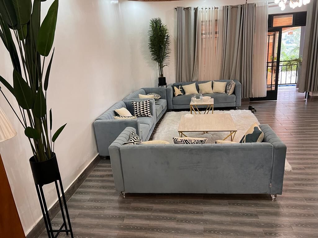 Un salon moderne avec un canapé d’angle gris, une table basse et une plante en pot.