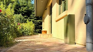 A paved pathway leading to a building with a yellow facade and green window frames. - New: High-End Design Lodge Surrounded by Nature – Teos im Wiedergut (Sternberg)
