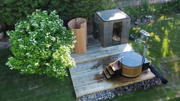 A wooden deck with a hot tub, a sauna, and a small shed. - New: High-End Design Lodge Surrounded by Nature – Teos im Wiedergut (Sternberg)