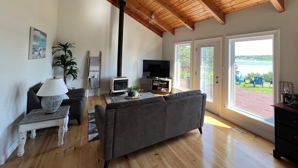 Un salon avec une cheminée, un canapé, un téléviseur et une vue sur l’extérieur.