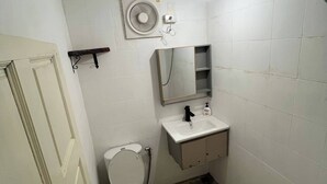 A small, basic bathroom with a toilet, sink, and mirror. - A Peaceful Cozy Home, Will Truly Refresh Your Soul (Koh Samui)
