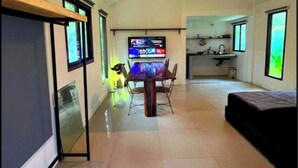 A spacious room with a dining table, chairs, a TV, a ceiling fan, and a bed. - A Peaceful Cozy Home, Will Truly Refresh Your Soul (Koh Samui)