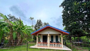 A small, single-story building with a red roof and white walls, surrounded by a wire fence and lush greenery. - A Peaceful Cozy Home, Will Truly Refresh Your Soul (Koh Samui)