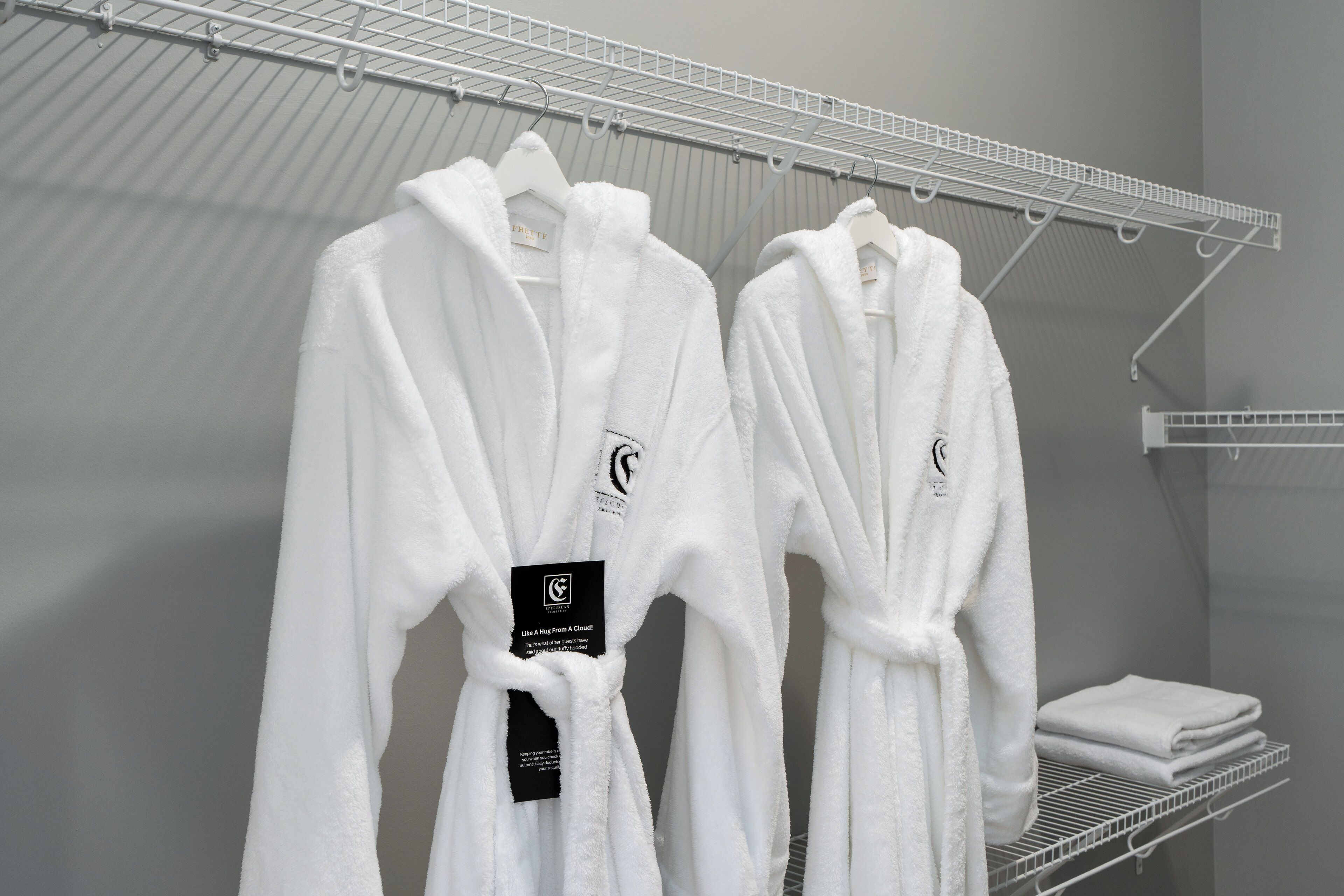 Un porte-vêtements avec des robes blanches et une serviette pliée.