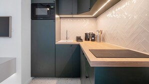 Una cocina moderna con microondas, lavamanos y encimera de madera.