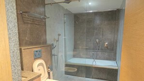 Un baño moderno con ducha vidriada, inodoro y lavamanos.