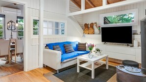 A cozy living room with a white sofa, a coffee table, a flat-screen TV, and a wood-burning stove. - "Unto" - 6km from the sea by Interhome (Esbjerg V)