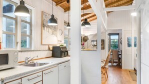 A modern kitchen with white cabinets, a built-in microwave, and pendant lighting. - "Unto" - 6km from the sea by Interhome (Esbjerg V)