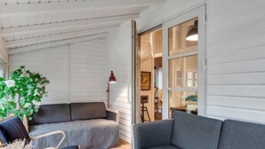 A modern living room with a grey sofa, a wooden chair, a potted plant, and a red floor lamp. - "Unto" - 6km from the sea by Interhome (Esbjerg V)