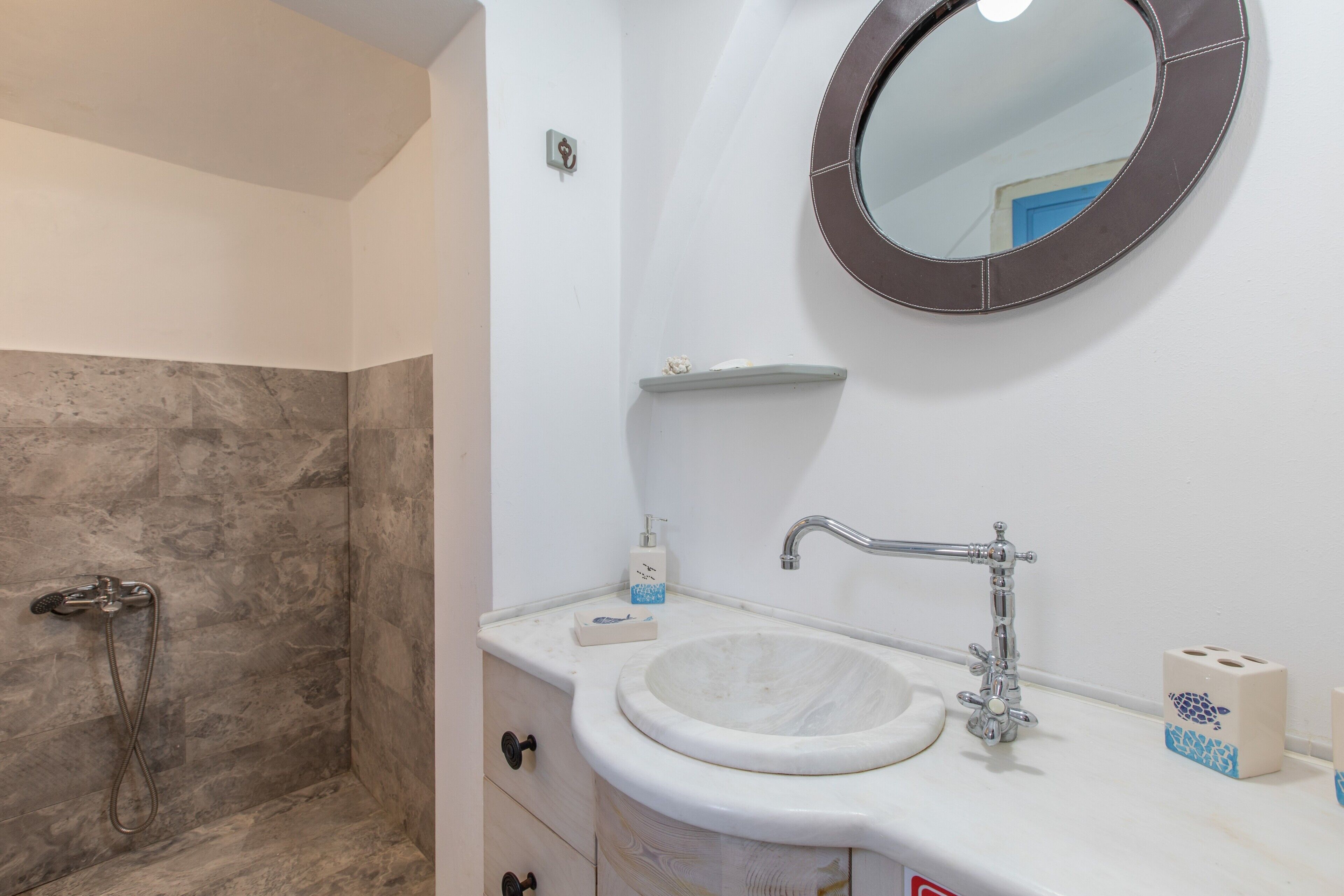 A bathroom with a shower, a sink, and a mirror.