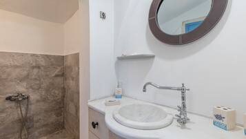 A bathroom with a shower, a sink, and a mirror.