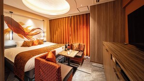 A hotel room with a bed, seating area, TV, and a large decorative fish mural.