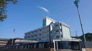 A multi-story hotel with a prominent 'Hotel Ride' sign, a modern architectural design, and a clear blue sky.