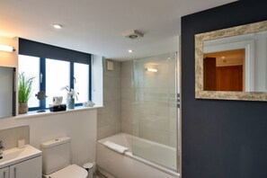 Een moderne badkamer met toilet, wastafel en douchecabine.