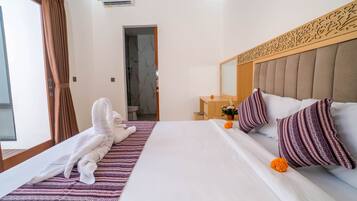 A hotel room with a bed, a bathroom, and a view of the outside.