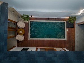 A spa area with a large rectangular hot tub, wooden panel walls, and two potted plants. - Andorra Villa Nusa Dua (Badung)