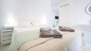 Ein Hotelzimmer mit einem Bett, einem Kleiderschrank, einem Spiegel und einem Fenster.