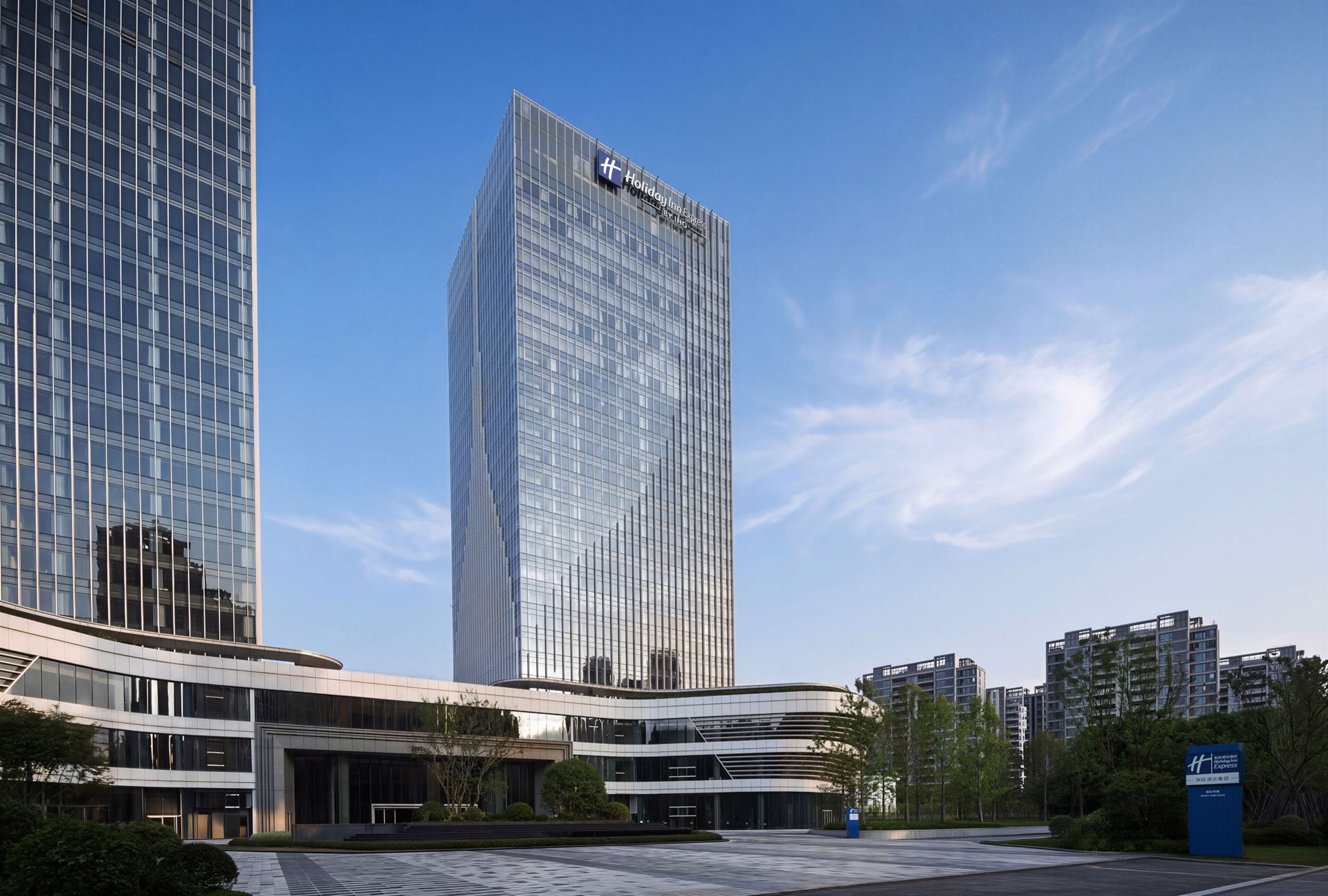 Un edificio moderno de hotel con una fachada de vidrio destacada y un letrero que indica que es un Holiday Inn Express.