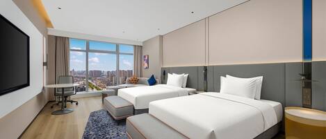 Una habitación de hotel moderna con dos camas, un escritorio y un amplio ventanal con vistas a la ciudad.