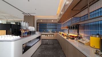 Una cocina moderna con piso de mármol, estación de café y zona de bufé.
