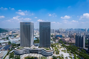 A modern building complex with two prominent skyscrapers, surrounded by a cityscape.