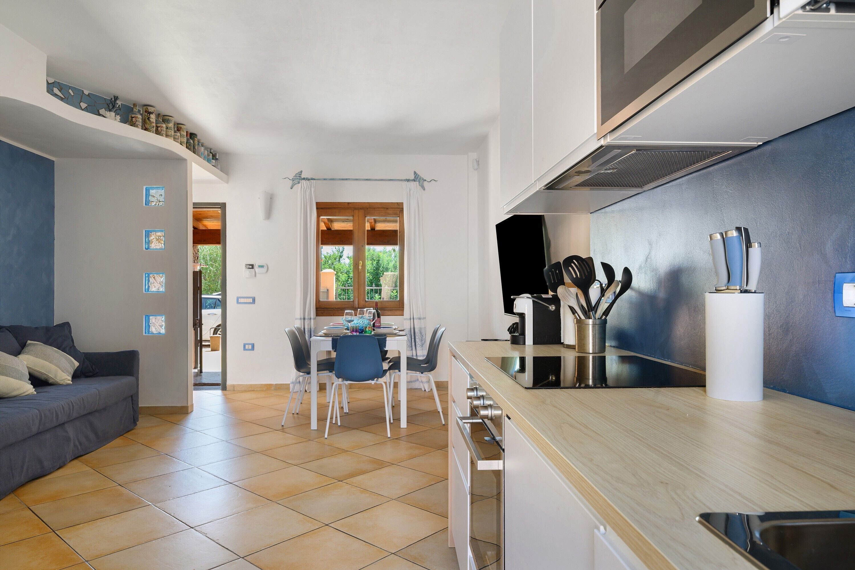 Una cucina moderna con zona pranzo, un divano e vista dalla finestra.