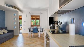 Una cucina moderna con zona pranzo, un divano e vista dalla finestra.