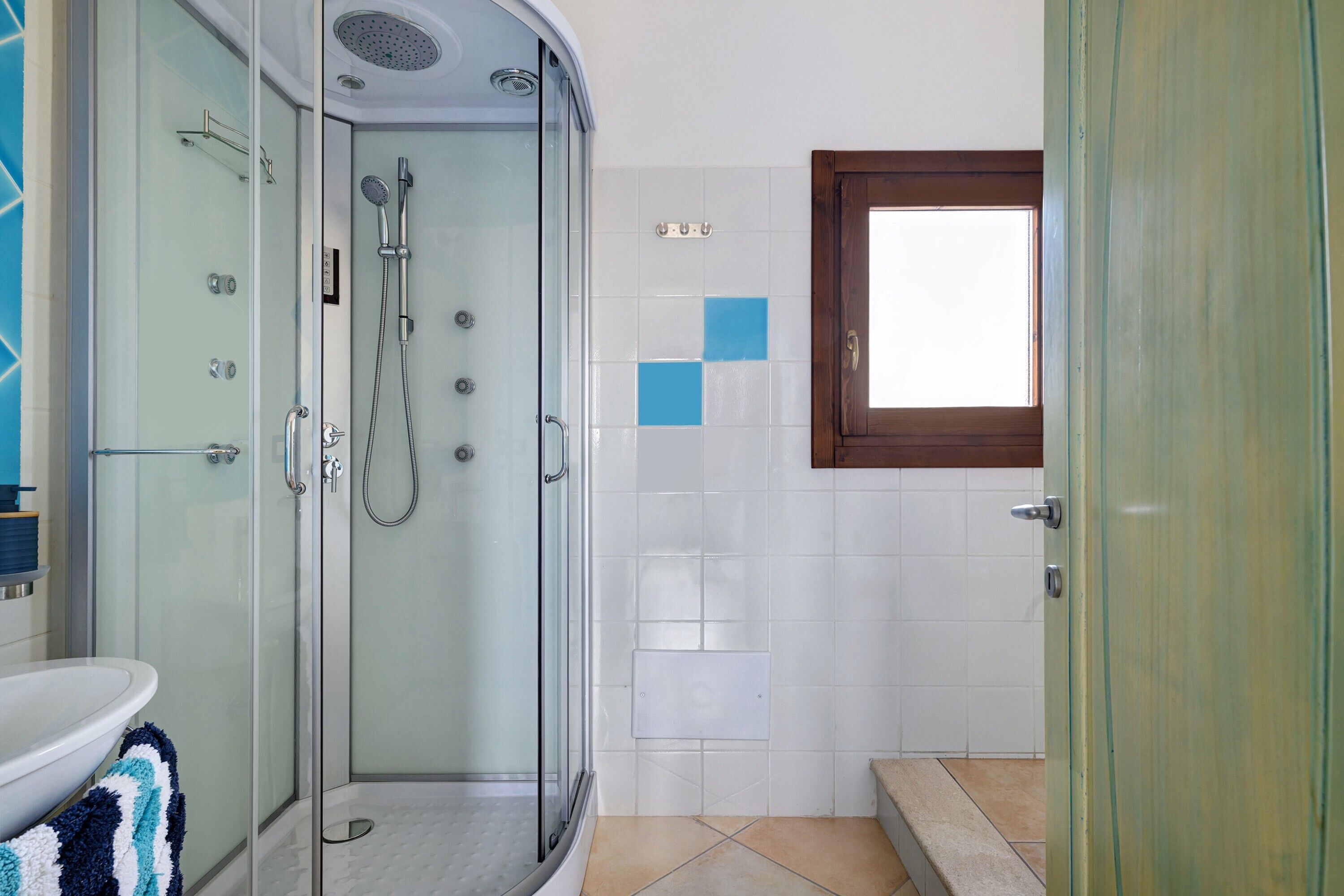 Un bagno con doccia vetro, un water e un lavandino.