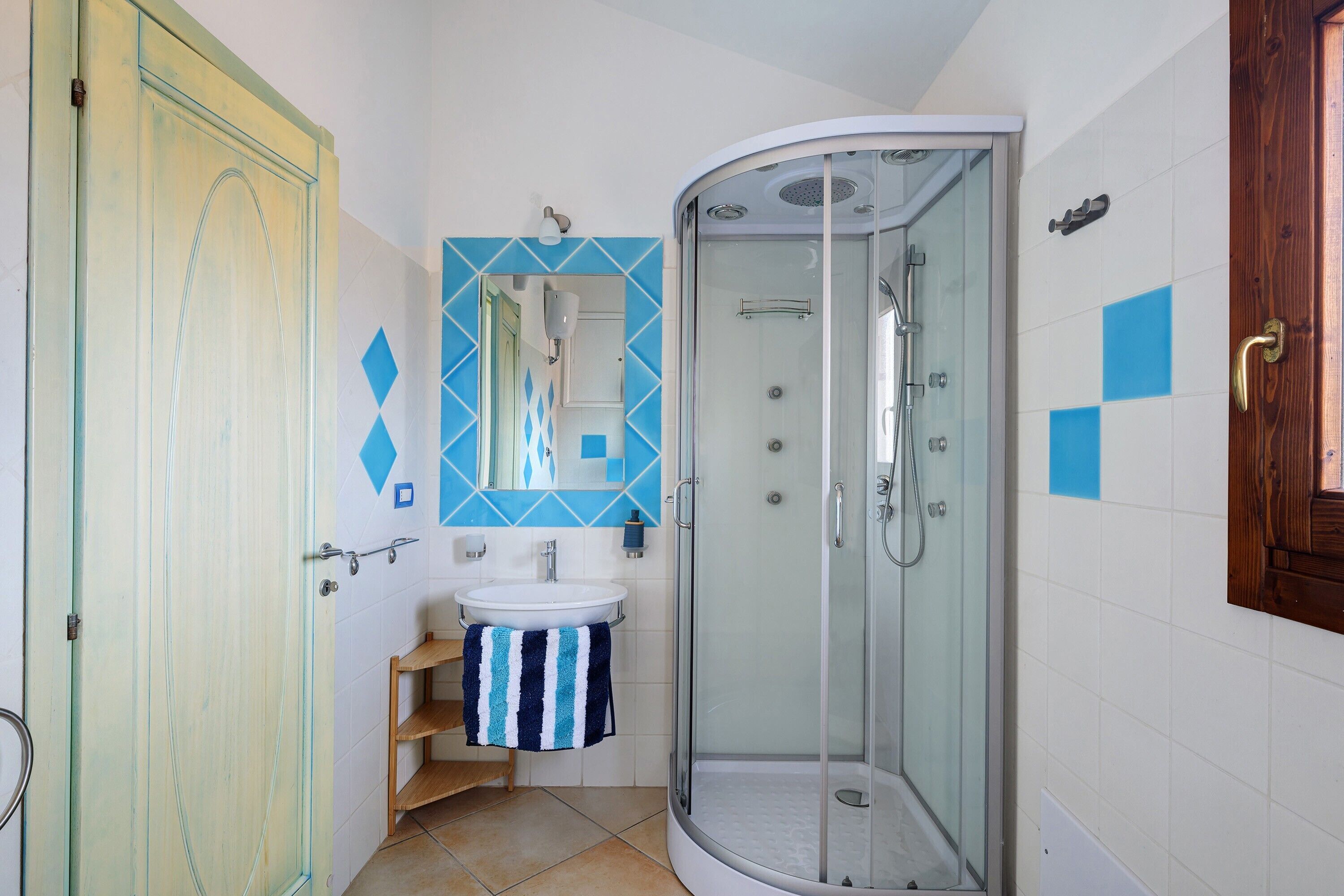 A bathroom with a shower, sink, and a mirror.